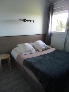 a bedroom with a bed with two pillows and a window at Hôtel Bon Repos in Barbezieux-Saint-Hilaire