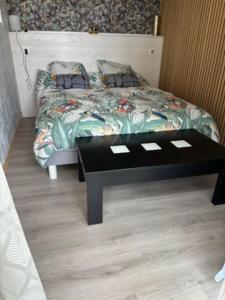 a room with a bed with a table and a bed with at L'Opaline in Les Épesses
