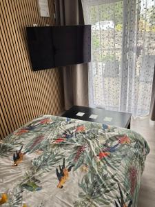 a bed with a comforter with birds on it at L'Opaline in Les Épesses