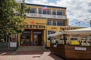 een geel gebouw met een bord erop bij Hotel Restaurant Seestern in Heiligenhafen
