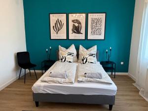 a bedroom with a large bed with a blue wall at Home&Living - Casa Nova in Meerbusch