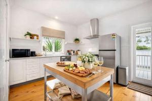 a kitchen with a table with a plate of food on it at 4 Bed Queenslander City Views Walk to Suncorp Deck + Parking in Brisbane