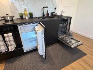 an open refrigerator in a kitchen with a sink at Home&Living - Casa Nova in Meerbusch