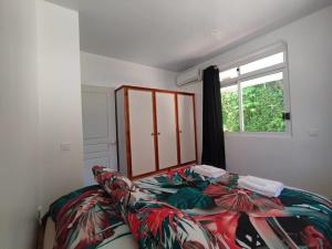 a bedroom with a bed and a window at Bungalow Hoarai in Uturoa