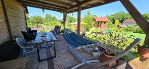 a hammock on a patio with a table and chairs at Agroturystyka u Joli in Pacanów