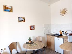 a kitchen with a table and a small table and chairs at Panoráma Apartman in Vác +12 photos