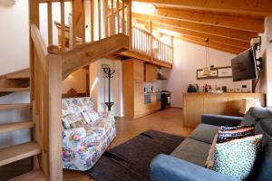 - un salon avec un canapé et un escalier dans l'établissement Residenza Bagni & Miramonti, à Cavalese