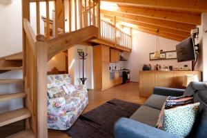 a living room with a couch and a staircase at Residenza Bagni & Miramonti in Cavalese