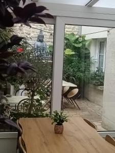 a table with a plant in front of a window at Le Declic in Bayeux