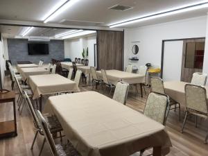 a conference room with tables and chairs and a screen at Aizu Tsuruya Hotel in Aizuwakamatsu