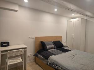 a bedroom with a bed and a desk with a chair at A&A Apartment Vilnius 2 in Vilnius