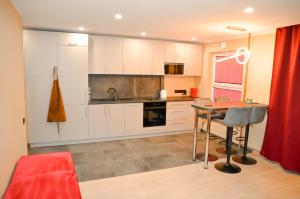 a kitchen with white cabinets and a table at Merķeļa apartamenti in Valka