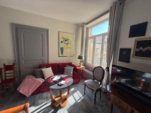 a living room with a red couch and a table at Villa Bartholdi in Colmar
