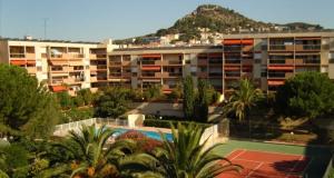 an apartment building with a swimming pool and a mountain at Appartement calme, clim, patio XXL, piscine&parking in Hyères