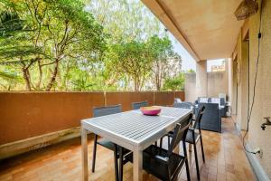 a table and chairs on a patio with a fence at Appartement calme, clim, patio XXL, piscine&parking in Hyères