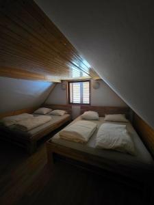 two beds in a room with a attic at Tijekova koča in Hočko Pohorje