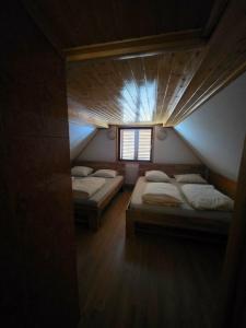 a room with two beds and a window at Tijekova koča in Hočko Pohorje +4 photos