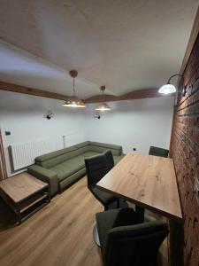 a room with a couch and a table and chairs at Tijekova koča in Hočko Pohorje