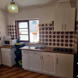 a kitchen with a sink and a microwave at Casa Nelinha by Rosado in Luz