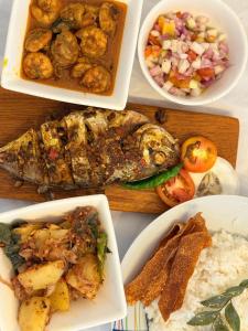 a table with four different dishes of food on it at Ancestral Aura in Negombo