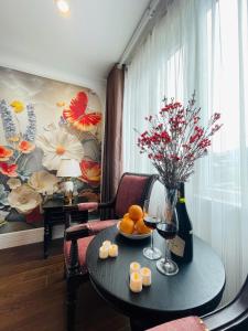 a room with a table with fruit and a vase of flowers at Diamond Villa in Hanoi