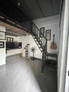 a living room with a spiral staircase and a guitar at Lavish style at Laguna by Nelson in Biñan