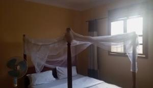 a bird perched on top of a bed in a bedroom at Palace Royal Hotel in Kagadi