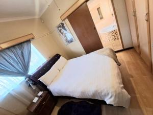 a small bedroom with a bed and a window at Minelo Guesthouse in Virginia