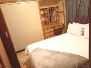 a small bedroom with a bed and a cabinet at Minelo Guesthouse in Virginia