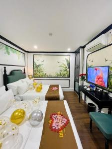 a room with two beds and a flat screen tv at Diamond Villa in Hanoi