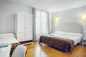 ein Hotelzimmer mit 2 Betten und einer Kommode in der Unterkunft Casual Gurea in Bilbao