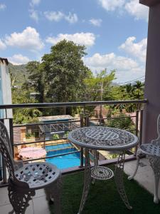 a balcony with a table and chairs and a pool at Aonang Mountain View A1 in Ao Nang Beach