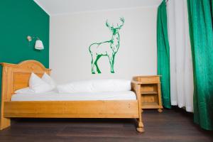 a bedroom with a bed with a deer sticker on the wall at Stadthotel Augsburger Hof in Landsberg am Lech
