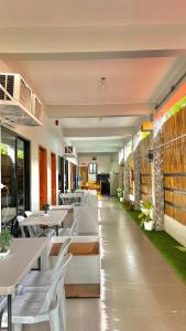 a restaurant with white tables and white chairs at Quartz Suites in Camiguin +1 photo