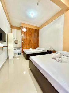 a hotel room with two beds and a bathroom at Quartz Suites in Camiguin