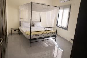 a bedroom with a metal bed with a canopy at Villa Amani in Somone +14 photos