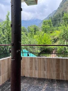 a balcony with a wooden fence and a view of a mountain at Himvilla Kasol in Jāmb