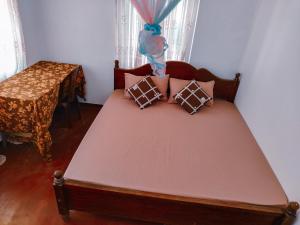 a bed with pillows on it in a room at Shan Inn Midigama in Midigama East