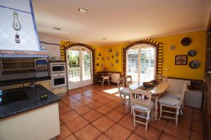 a kitchen with yellow walls and a table and chairs at Villa la cantera in Guadarrama