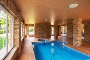 a large swimming pool in a house with a large room at Villa la cantera in Guadarrama