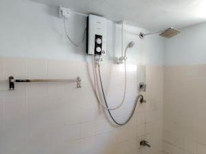 a shower in a bathroom with white tiles at Shan Inn Midigama in Midigama East