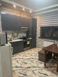 a kitchen with gray cabinets and a wooden table at Seven Resedens 82-15 in Sergeli