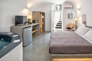 a bedroom with a bed and a tub in a room at Aetheria Villas in Oia +64 photos