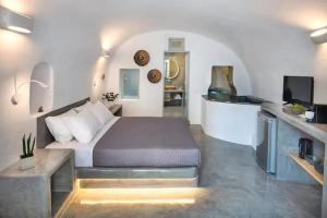 a bedroom with a bed and a television in it at Aetheria Villas in Oia