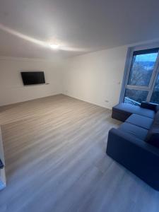 a living room with a blue couch and a large window at Ferienapartments Sternen WOHN 6 in Baiersbronn
