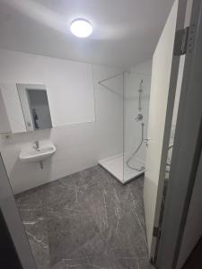 a white bathroom with a sink and a shower at Ferienapartments Sternen WOHN 6 in Baiersbronn +1 photo