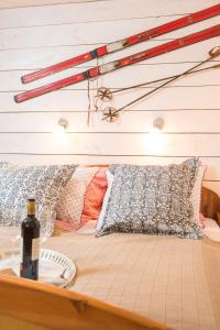 Bett mit Kissen und einer Flasche Wein in der Unterkunft Haus Emma in Bad Gastein