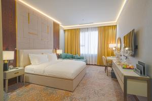 a hotel room with a bed and a desk at Grand Iva Hotel Abha in Abha