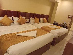 two beds in a hotel room with towels on them at Siddi Vinayaka hotel in Hyderabad +4 photos