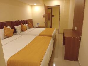 two beds in a hotel room with a mirror at Siddi Vinayaka hotel in Hyderabad